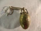 An egg shaped brass scent bottle on chain
