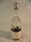 Cut glass bottle set in silver stand